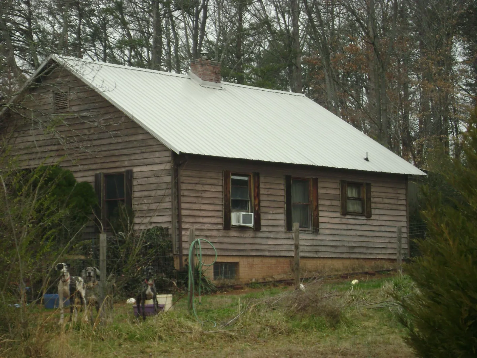 White metal roof on an old wood sided farmhouse, from a Metal Roof Installation job in Sylva